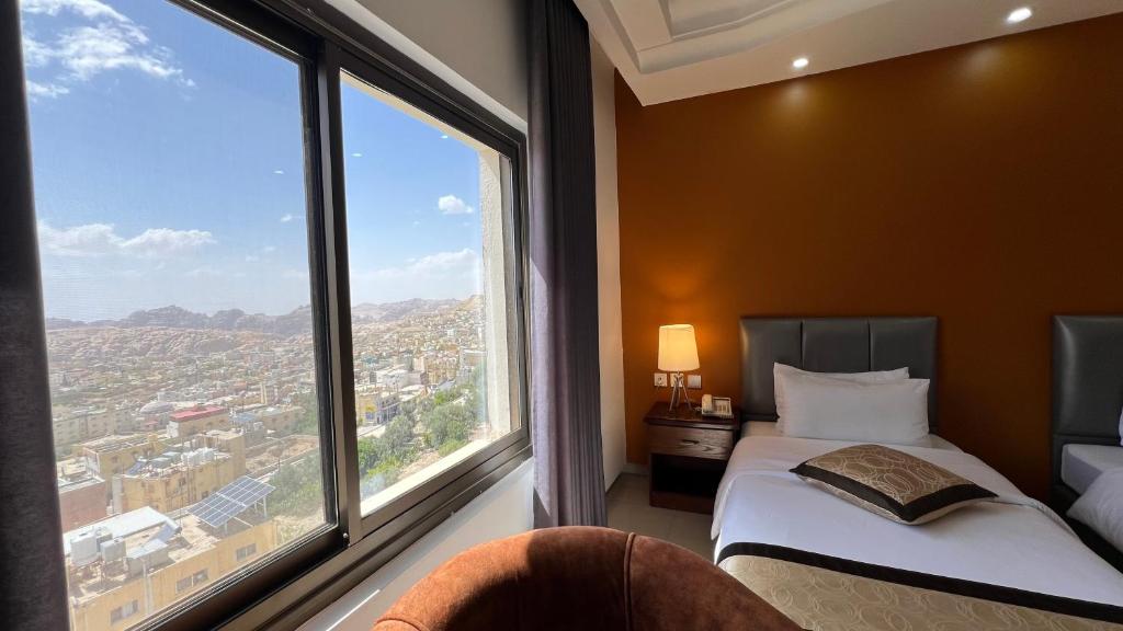 una camera d'albergo con un letto e una grande finestra di Tetra Tree Hotel 1 a Wadi Musa