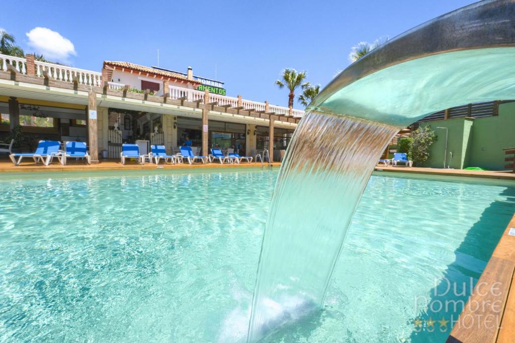 a water fountain in the middle of a swimming pool at Dulce Nombre Hotel - Apartamentos in Tarifa