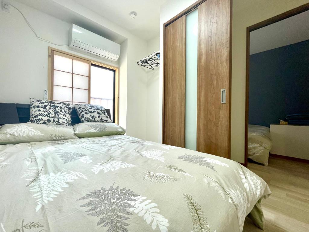 Postel nebo postele na pokoji v ubytování IMA Guesthouse 飛田新地イマ民宿