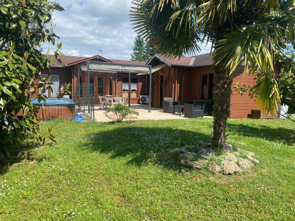 a house with a palm tree in the yard at Chalet chaleureux in Billy
