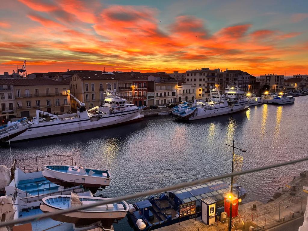 un groupe de bateaux amarrés dans un port au coucher du soleil dans l'établissement Studio climatisé - Vue canal Royal, à Sète