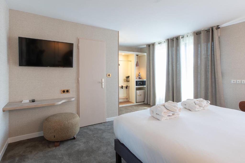Postel nebo postele na pokoji v ubytování Hôtel Henry II Beaune Centre