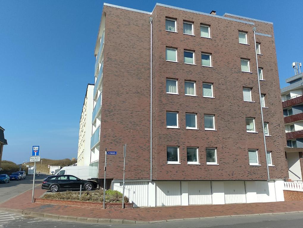 ein Backsteingebäude mit einem davor geparkt in der Unterkunft Strandappartement in Westerland