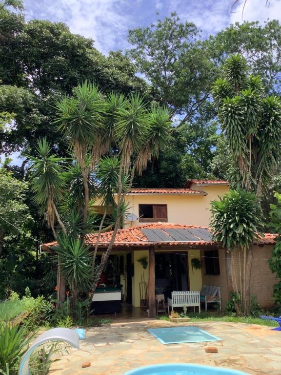 a house with palm trees in front of it at Casa Rústica com piscina in Pirenópolis