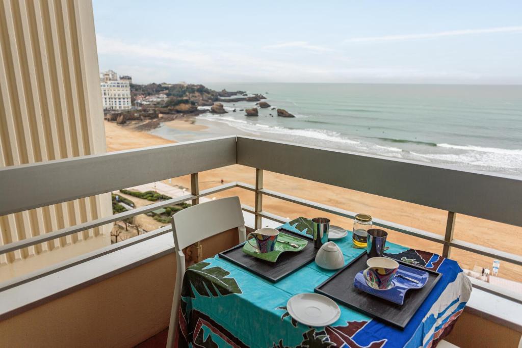 - une table sur un balcon avec vue sur l'océan dans l'établissement Studio les pieds dans l'eau à Biarritz, à Biarritz