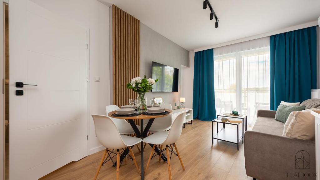 un soggiorno con un tavolo e un divano di Flatbook Apartamenty - Sztutowo Perła Mierzei a Sztutowo