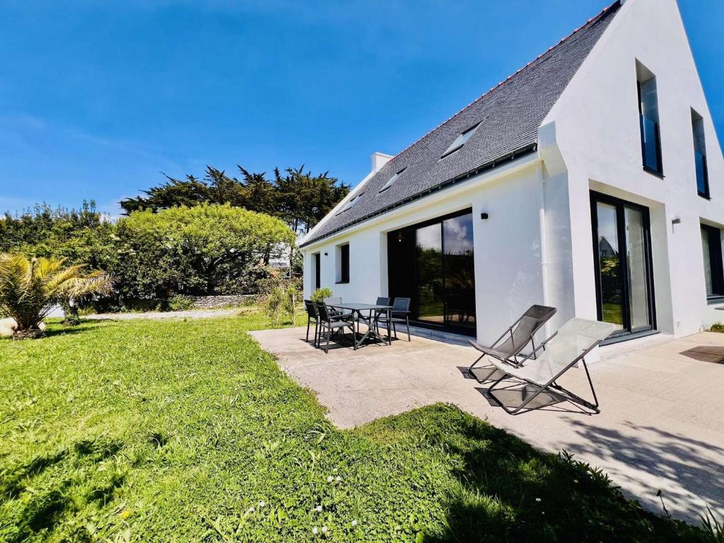 a white house with two chairs and a patio at Villa 7 pièces à Quiberon - Proche plage, jardin, parking, WiFi - FR-1-478-307 in Quiberon