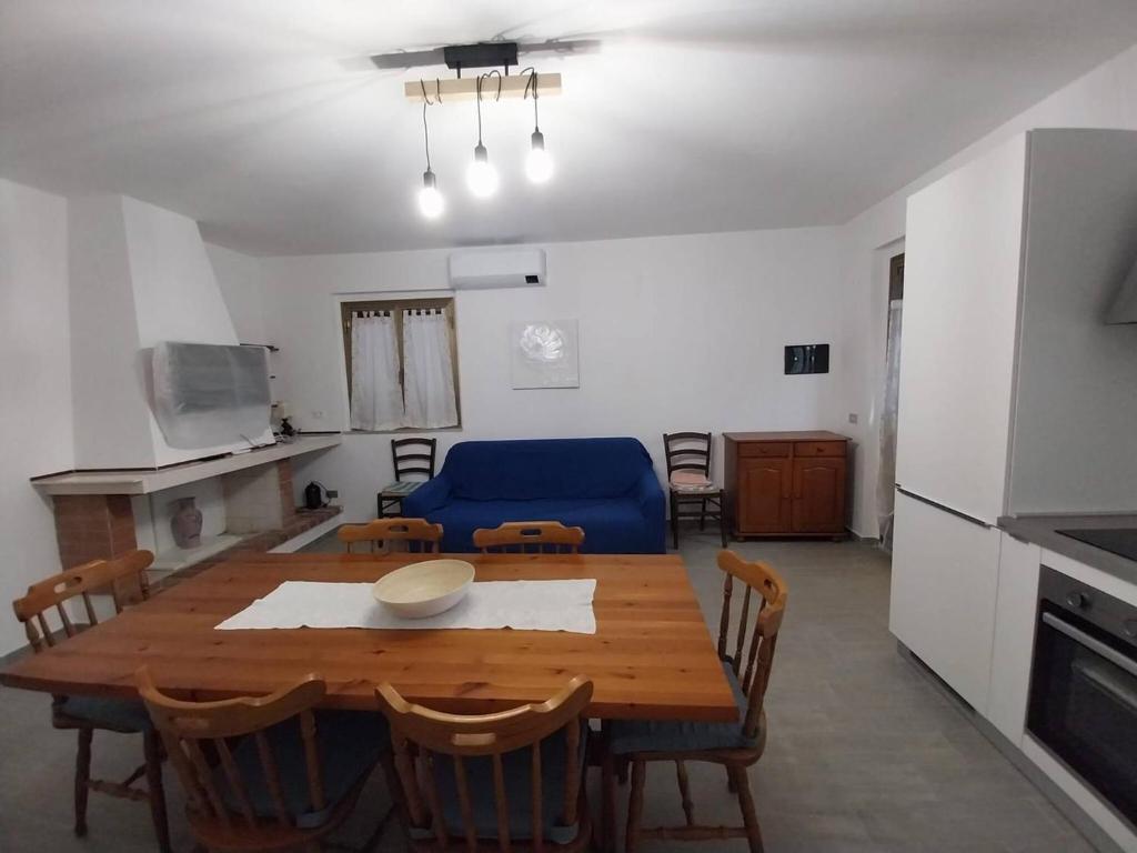 une salle à manger avec une table et un canapé bleu dans l'établissement Fpo-Fio42tp Casa su due Piani, 6 Pax A Ottiolu, à Porto Ottiolu
