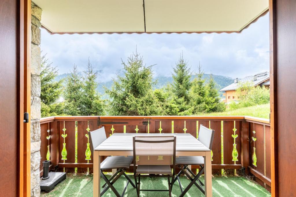 une table et des chaises sur un balcon avec vue dans l'établissement La Saulire, à Les Allues