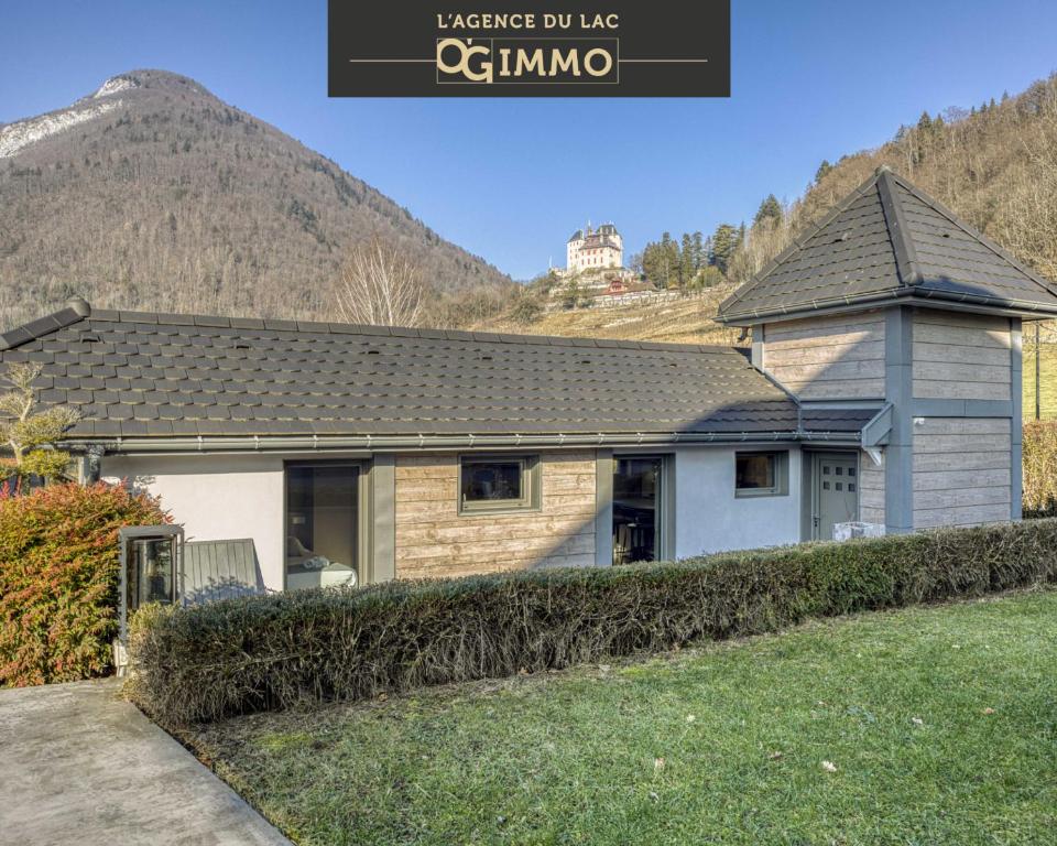 una casa con una montaña al fondo en Le pigeonnier, en Menthon-Saint-Bernard