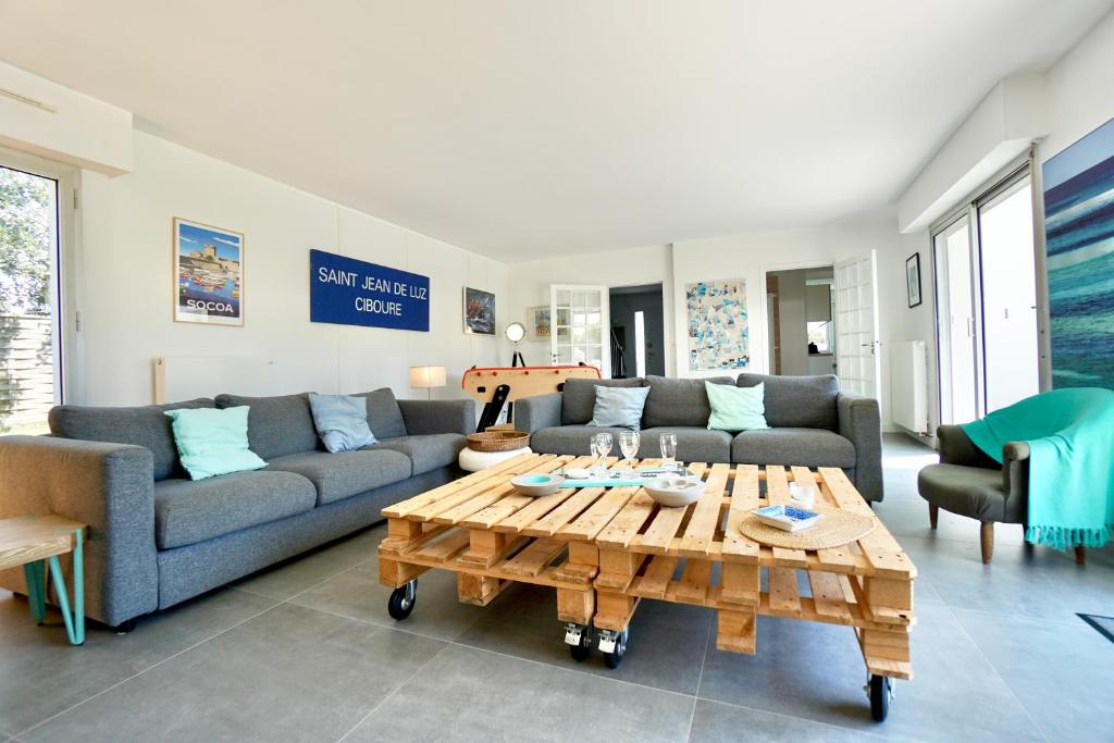 un salon avec un canapé et une table basse dans l'établissement Le cottage bleu - 400 m de la mer - parking, à Larmor-Plage