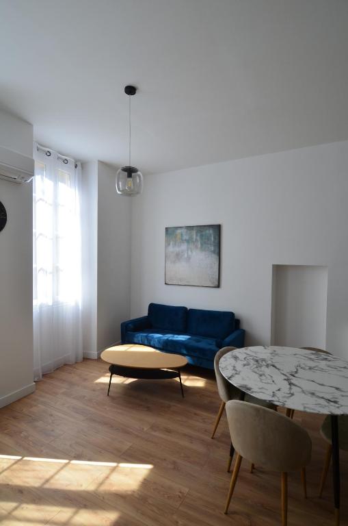 un salon avec un canapé bleu et une table dans l'établissement JAURES - Luxueux appartement quartier Vieux-Nice, à Nice