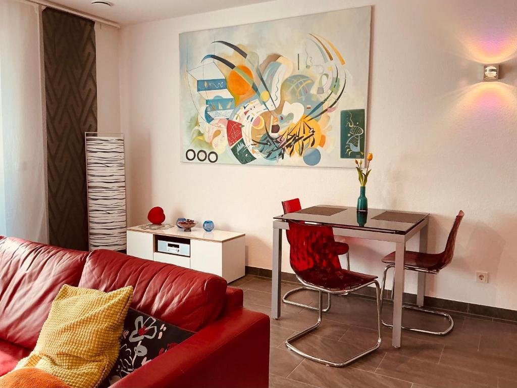 a living room with a red couch and a table at AAM Ferienwohnung 75qm Saarlouis citynah PP WiFi in Saarlouis