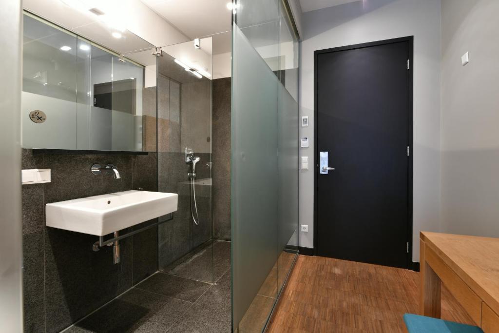 ein Bad mit einem Waschbecken und einem Spiegel in der Unterkunft The Bank Hotel in Amsterdam