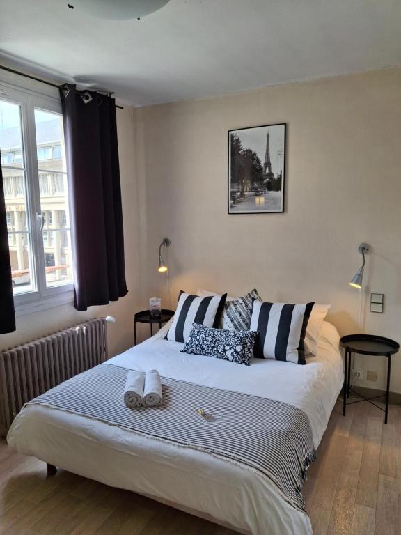 a bedroom with a large bed with black and white pillows at Logis Hôtel des Remparts - Saint-Lô in Saint Lo