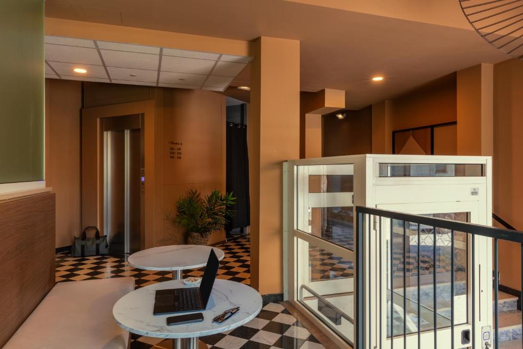 an office lobby with a desk and a laptop on a table at Bob W Ticinese in Milan