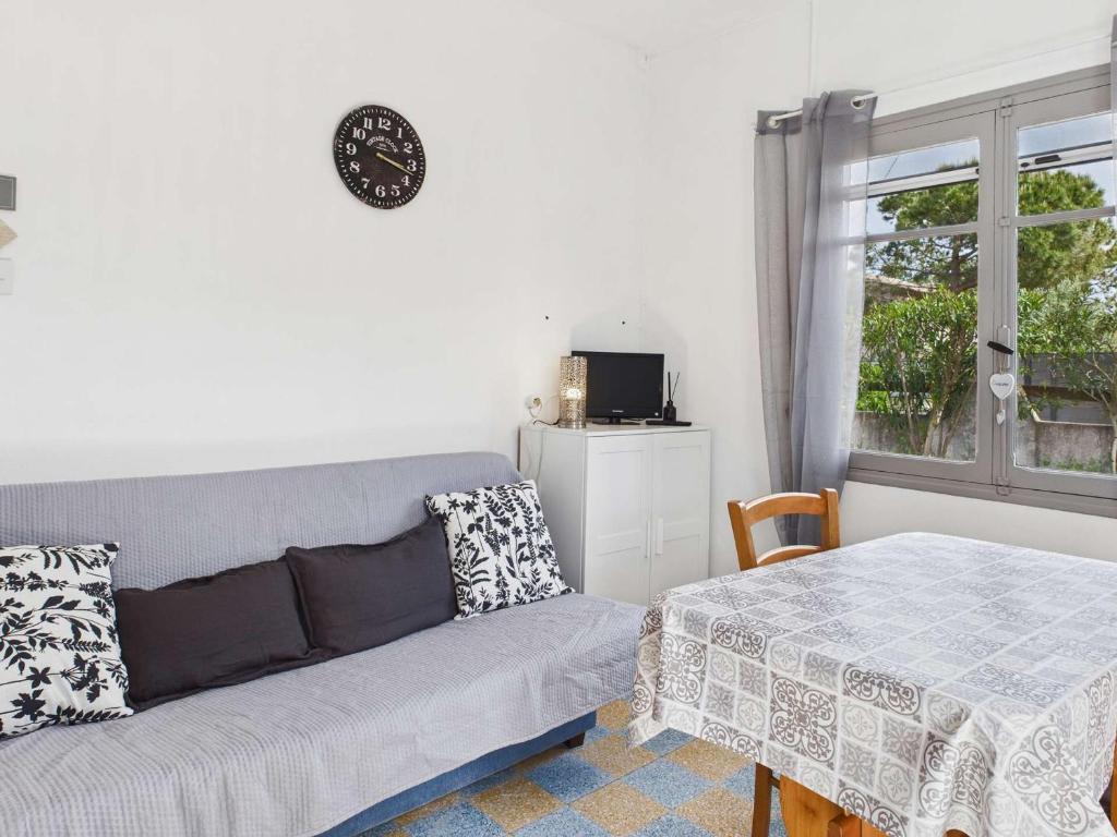un salon avec un canapé et une table dans l'établissement Appartement RDC 5 pers avec grande terrasse sud, proche marché, animaux admis - Marseillan Plage - FR-1-326-712, à Marseillan