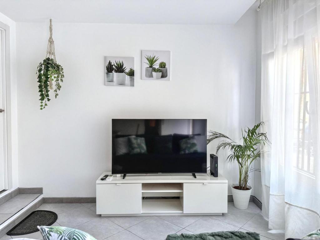 sala de estar blanca con TV de pantalla plana en Como en casa, en Parla