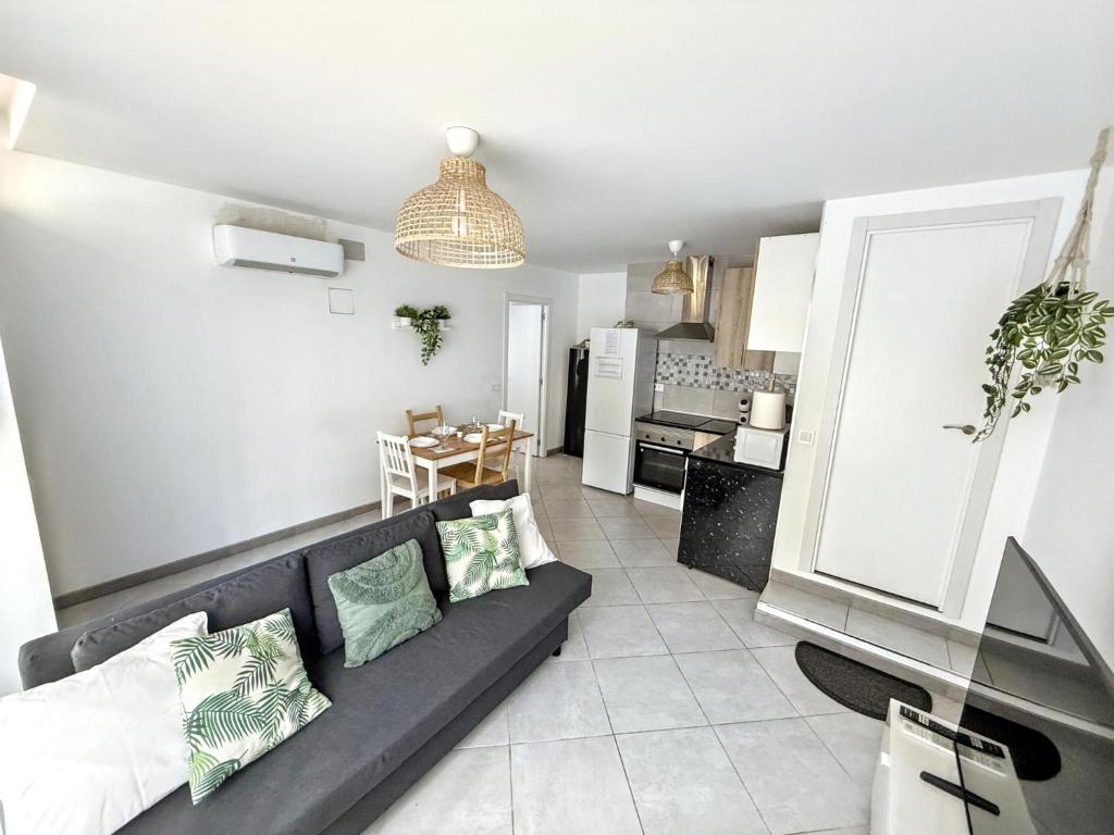 Una sala de estar con un sofá y una cocina. en Como en casa, en Parla