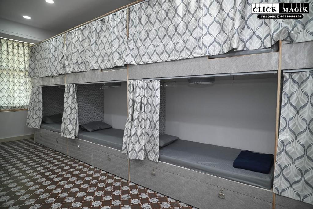 a room with three bunk beds with a checkered floor at Skyline backpackers in Hyderabad