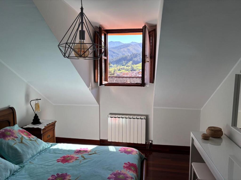 a bedroom with a bed and a window at La terraza de Los Picos de Europa in Potes