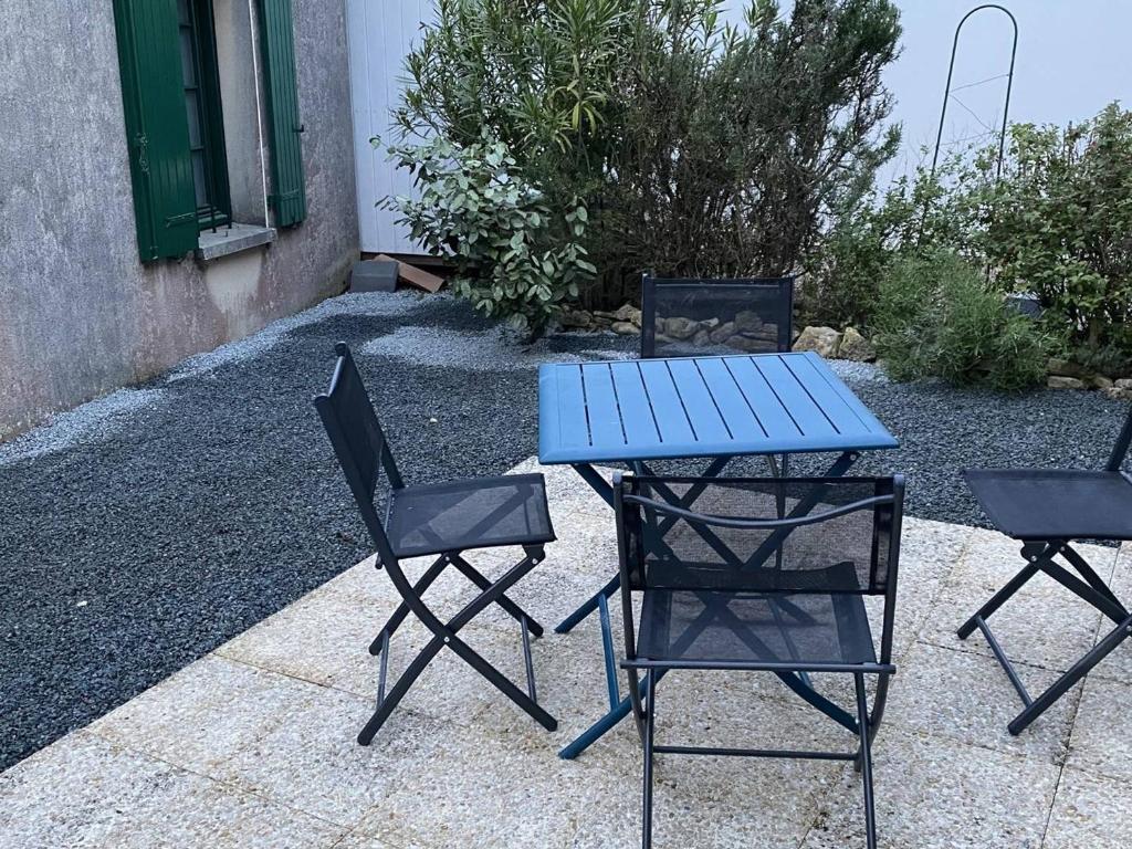2 chaises, une table bleue et 2 chaises dans l'établissement Maison spacieuse à Saint-Georges-d'Oléron, 7 couchages, proche commerces, jardin et barbecue - FR-1-246A-328, à Saint-Georges-dʼOléron