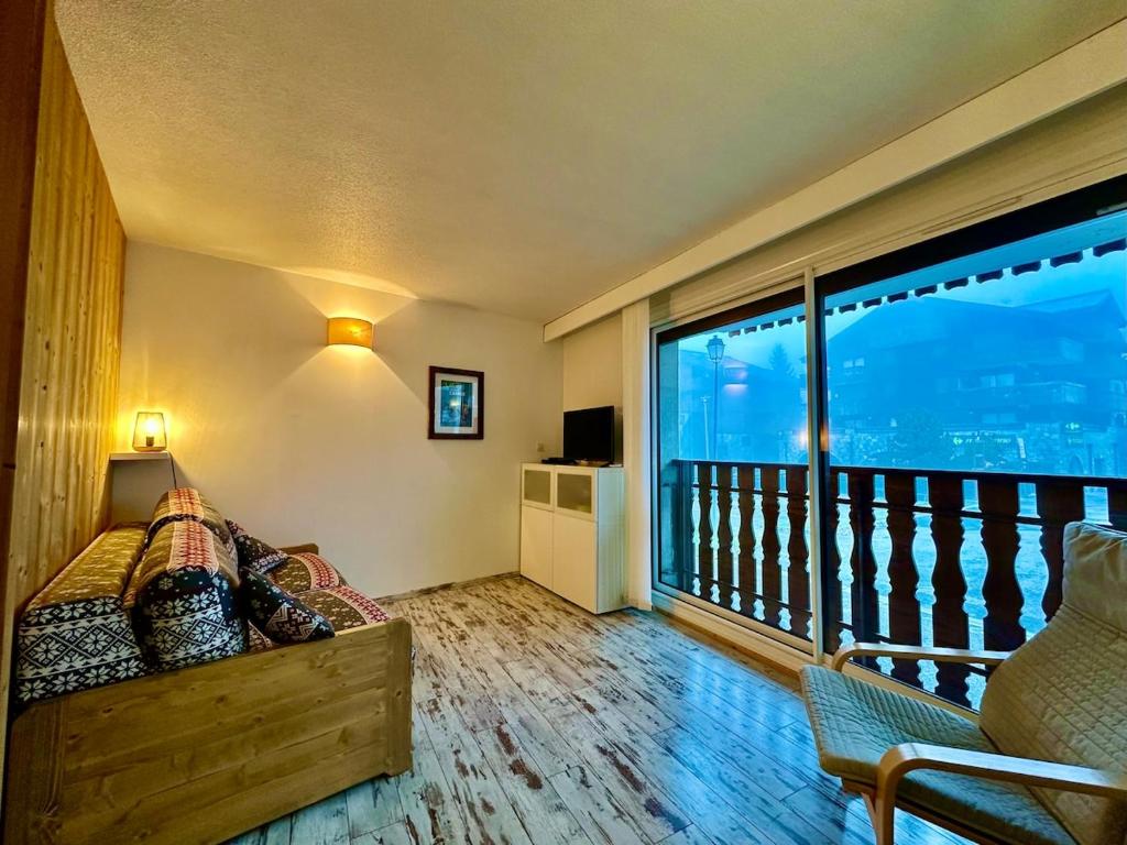 Cette chambre comprend un balcon avec un lit et une grande fenêtre. dans l'établissement appartement 4 personnes au coeur de la station des carroz d arâches, à Arâches-la-Frasse