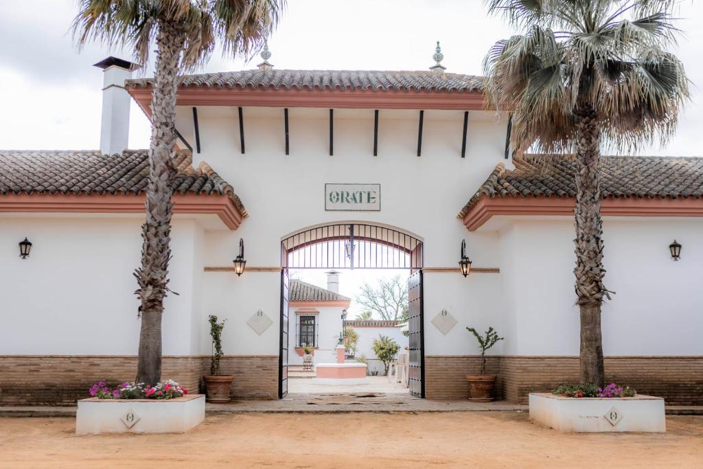 a view of the front of a building with palm trees at Finca Orate in Mairena del Alcor