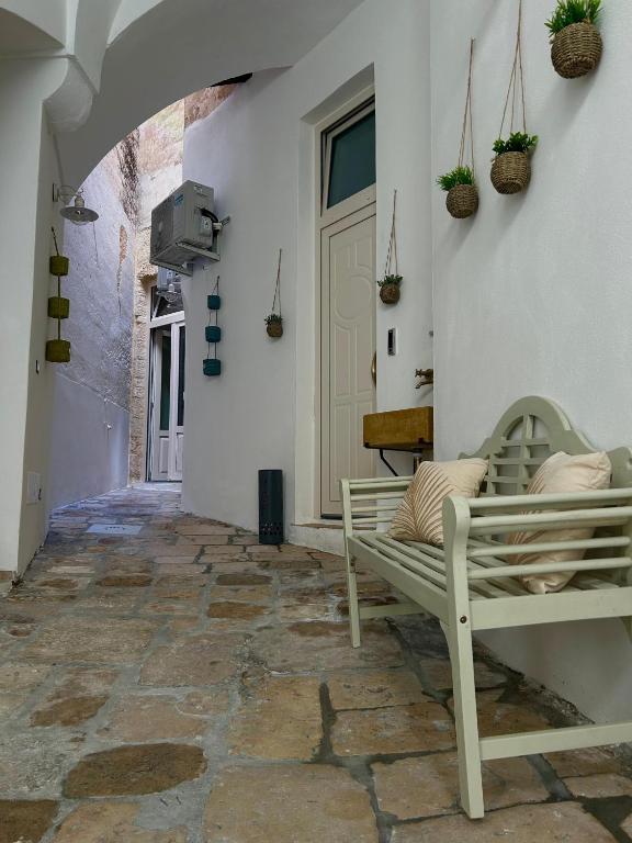 a porch with a bench on a stone floor at Dimore Remegi in Brindisi