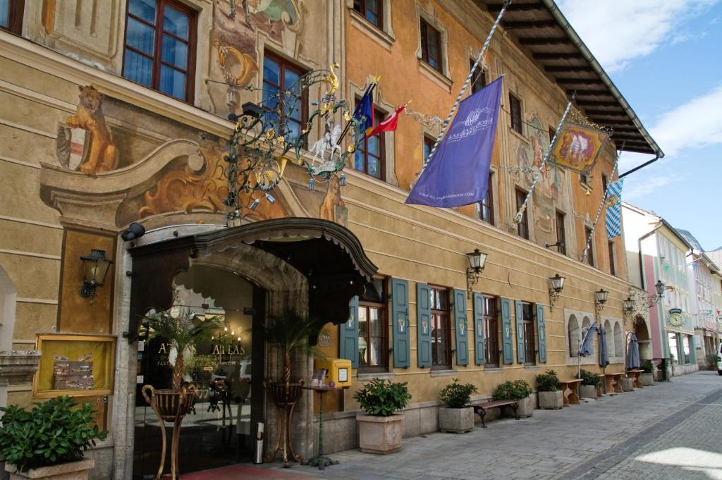 un edificio en una calle con banderas. en Atlas Grand Hotel, en Garmisch-Partenkirchen