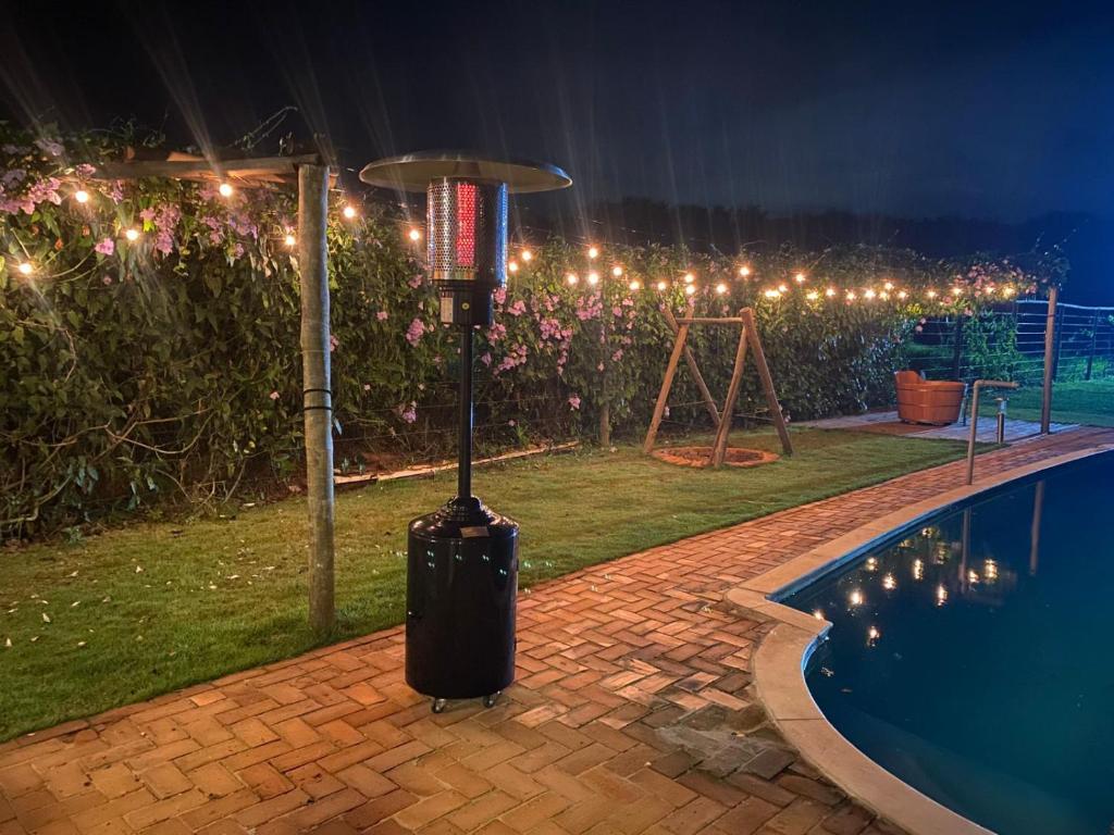 a trash can next to a swimming pool at night at Casa de Campo / Sítio + Chalé Suíço + Área Festa + Piscina in Tatuí