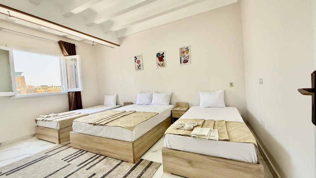 a bedroom with two beds and a window at Casa Del Sol deluxe in Cairo