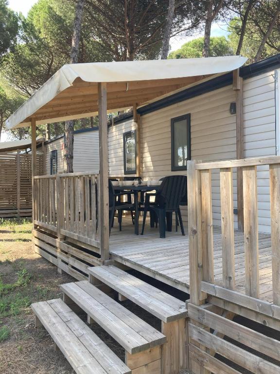 une terrasse en bois avec une table et une tente dans l'établissement L'Oasis des Pins, à Sète