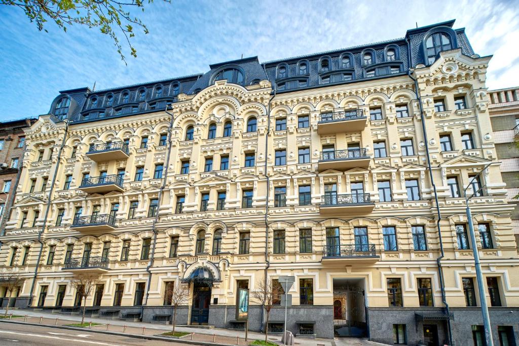 a large white building with a blue roof at CITYHOTEL Residence in Kyiv