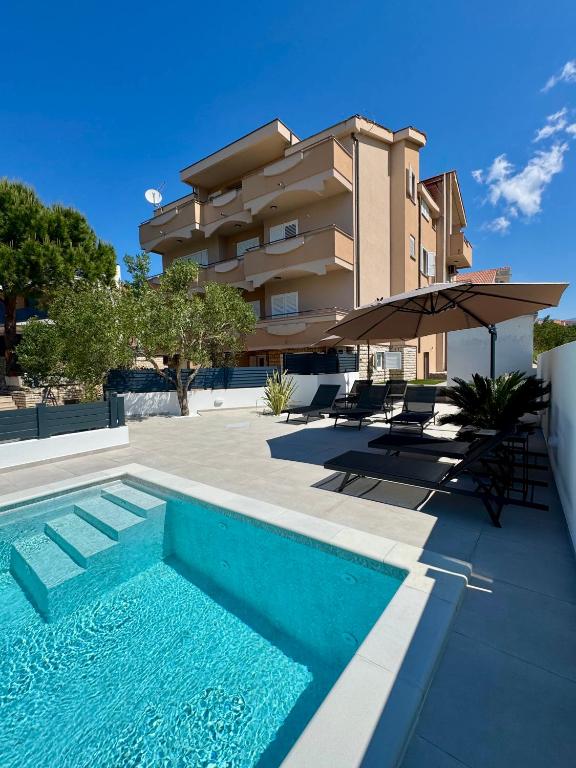 a swimming pool in front of a building at Apartments Toma in Novalja