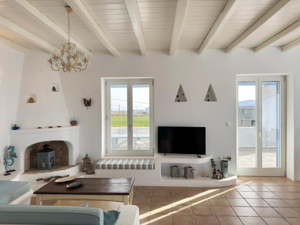 a living room with a tv and a fireplace at Sunny House in Pounda