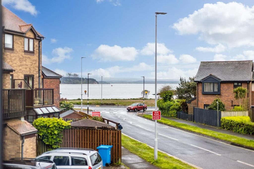 a street with houses and cars parked on the road at Anchorage - Quaint and Cosy Two-Bedroom House in Poole