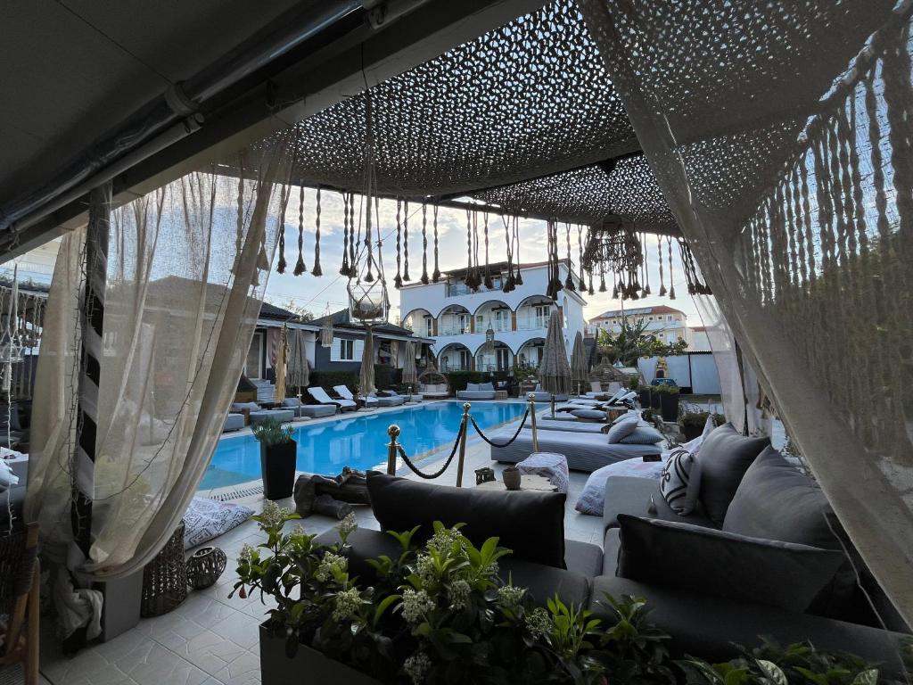 un patio extérieur avec des canapés et une piscine dans l'établissement Villa Corali Apartments Sea Breath & Pool, à Amoudi