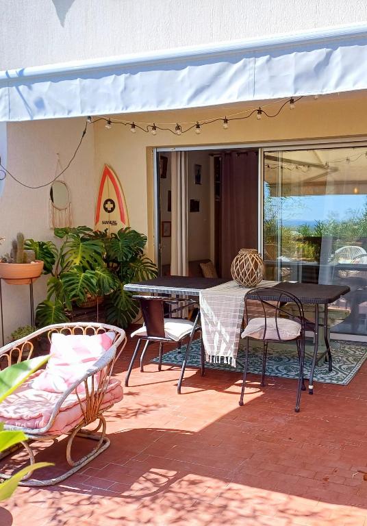 d'une terrasse avec une table et des chaises sous un auvent. dans l'établissement Charmant studio terrasse avec vue, plein sud, à Nîmes
