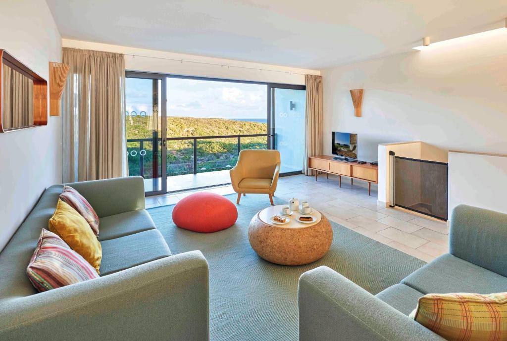 a living room with a couch and a tv at Martinhal Sagres Beach Family Resort Hotel in Sagres