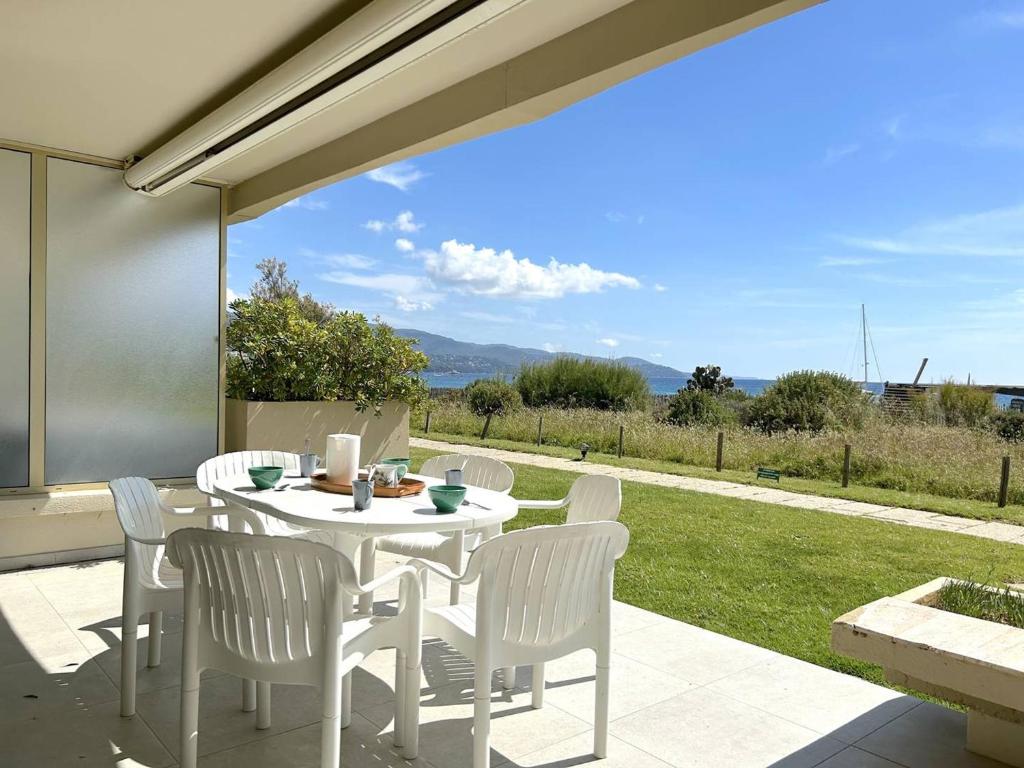 une table blanche et des chaises sur une terrasse dans l'établissement Appartement 3 pièces 4 couchages avec parking au Lavandou - FR-1-251-316, au Lavandou