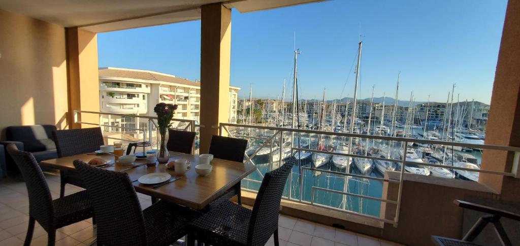 un balcon avec une table et des chaises et un port de plaisance dans l'établissement Residence Cap Hermes, Incroyable Vue sur le port,, à Fréjus