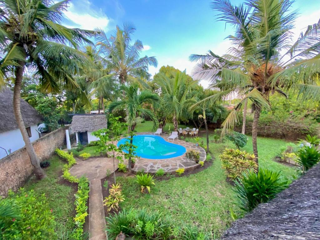 eine Luftaufnahme eines Resorts mit Swimmingpool und Palmen in der Unterkunft Villa Tata Diani in Diani Beach