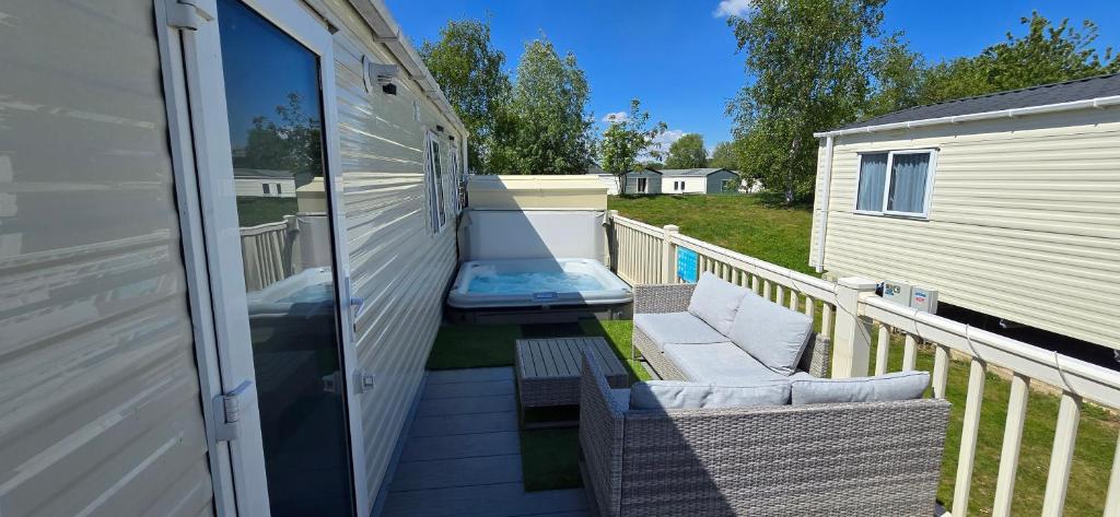 a balcony with two chairs and a bench on a porch at RJ Luxury Caravan Hire With Hot Tub in Tattershall