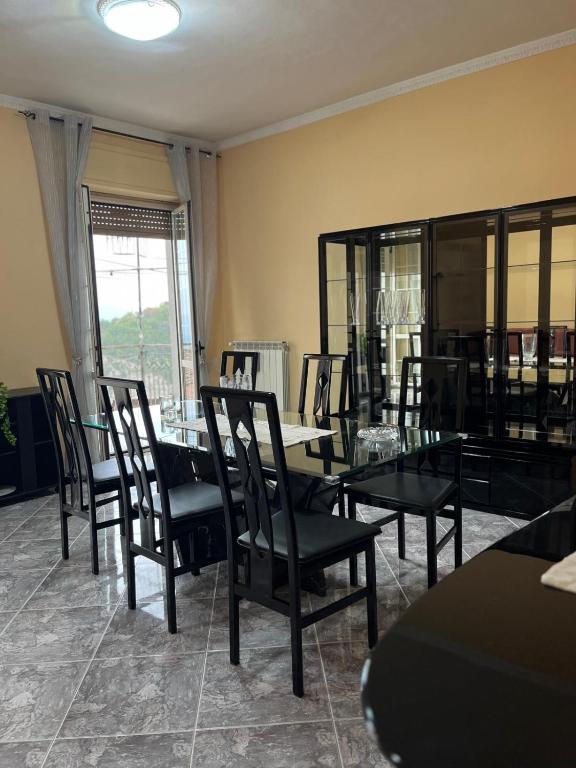 a dining room with black chairs and tables and a window at Casa Granitto in Castello del Matese