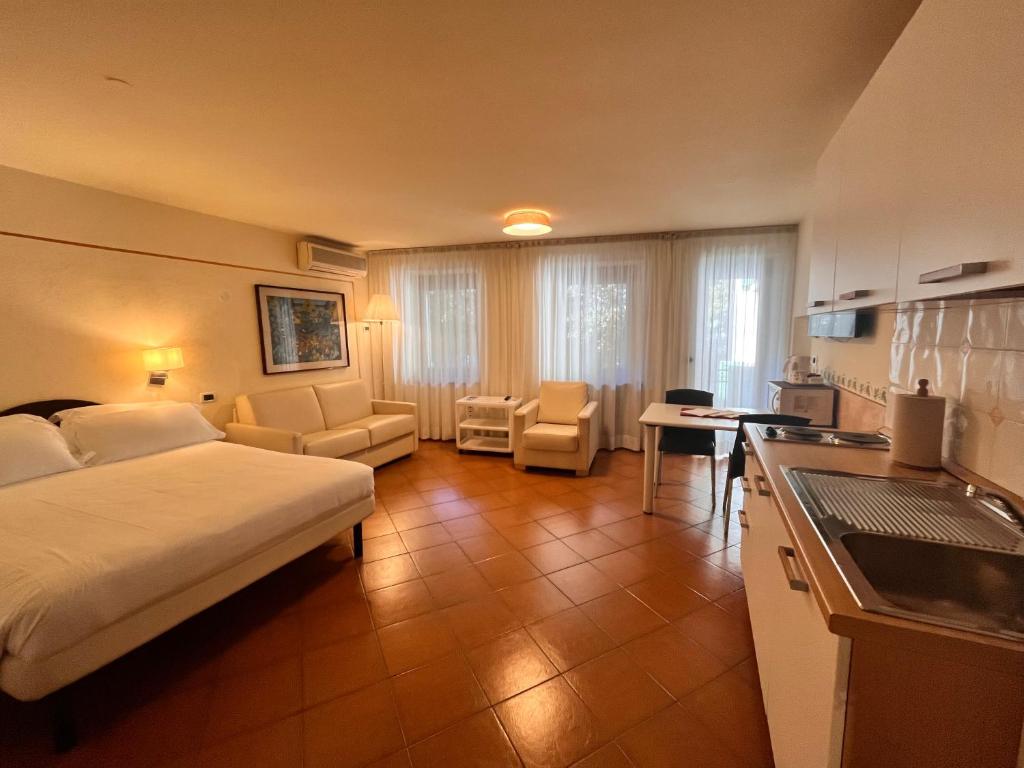 a hotel room with a bed and a kitchen at Pellico Apartments by Hotel America in Trento