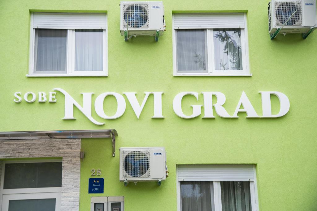 un edificio verde con un nuovo cartello per la laurea di Sobe Novi grad a Osijek