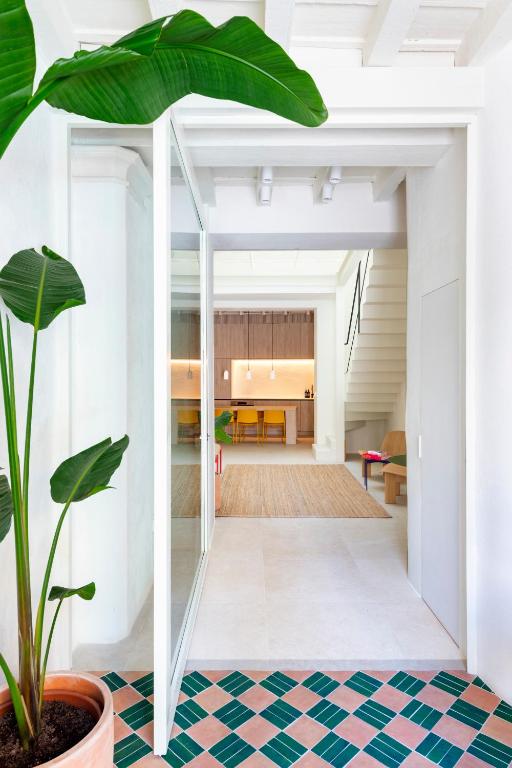 a living room with a potted plant and a staircase at Unika Homes Casa Bella in Seville