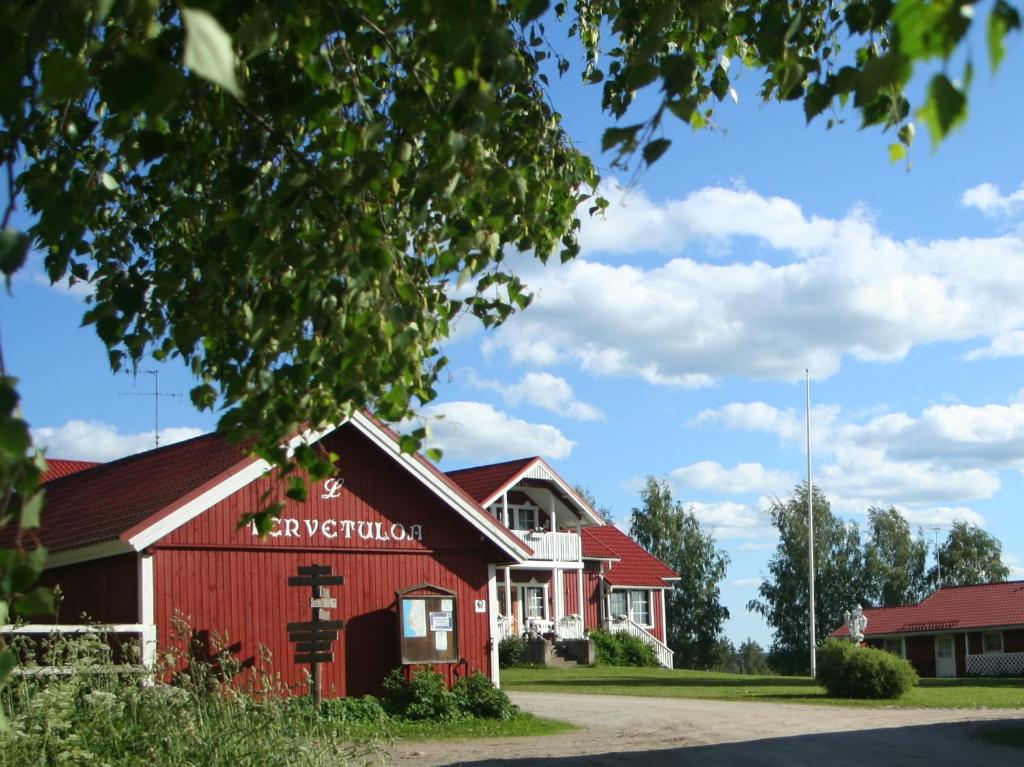 a red barn in front of a building at Matkailutila Lahdelma in Pertunmaa
