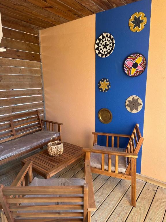 une chambre avec deux bancs et des horloges sur le mur dans l'établissement Appartement dans résidence 3 étoiles, à Porto-Vecchio